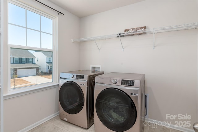 laundry area with separate washer and dryer and light tile patterned floors