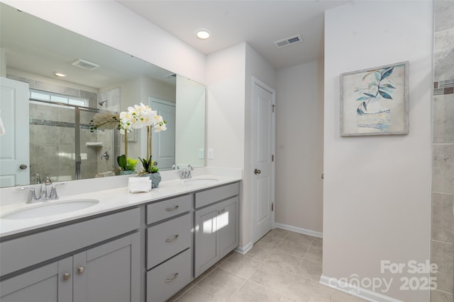 bathroom with tile patterned flooring, vanity, and a shower with shower door