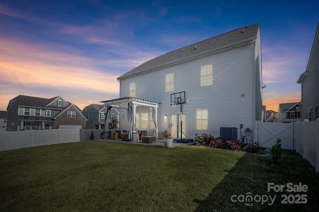 back house at dusk featuring a pergola, a lawn, and central air condition unit