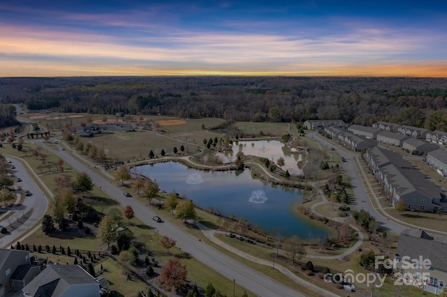 aerial view at dusk featuring a water view