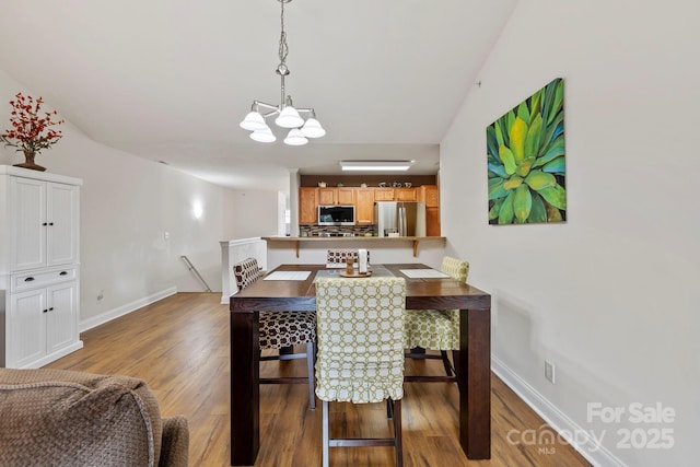 dining area featuring hardwood / wood-style flooring and an inviting chandelier