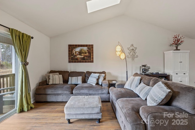 living room featuring lofted ceiling with skylight and light hardwood / wood-style flooring