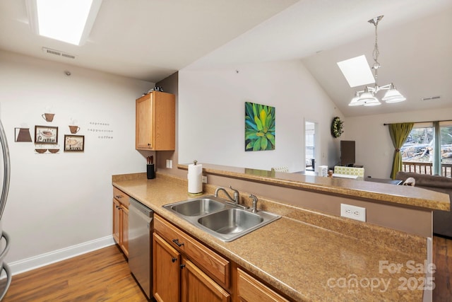 kitchen featuring dishwasher, kitchen peninsula, sink, and hanging light fixtures