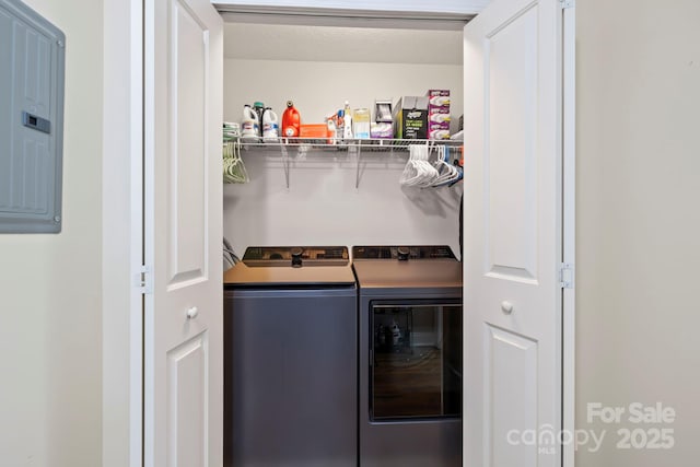 laundry room with electric panel and washer and dryer