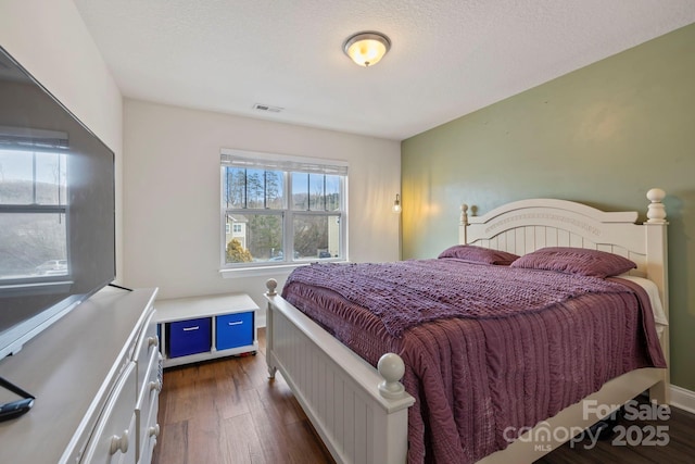 bedroom featuring dark hardwood / wood-style flooring and a textured ceiling