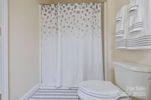 bathroom with toilet and curtained shower