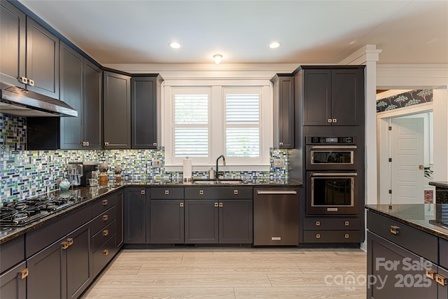 kitchen featuring sink, stainless steel appliances, dark stone counters, and tasteful backsplash