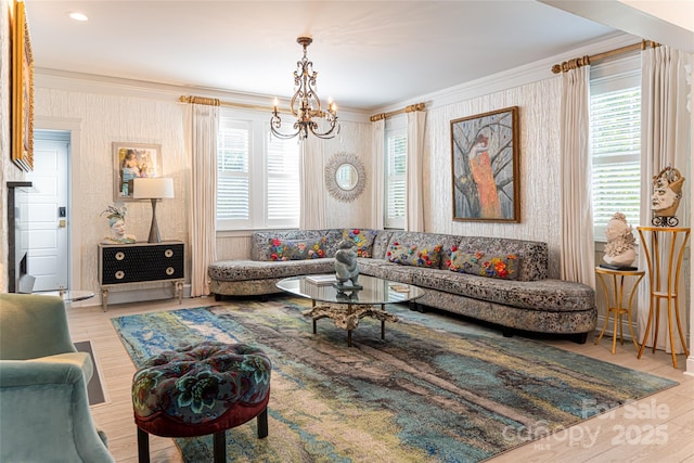 living room featuring hardwood / wood-style flooring, a chandelier, and ornamental molding