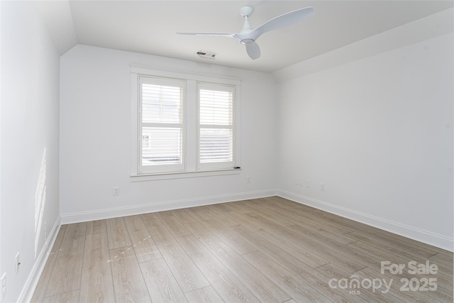 empty room with ceiling fan, light wood-type flooring, and lofted ceiling