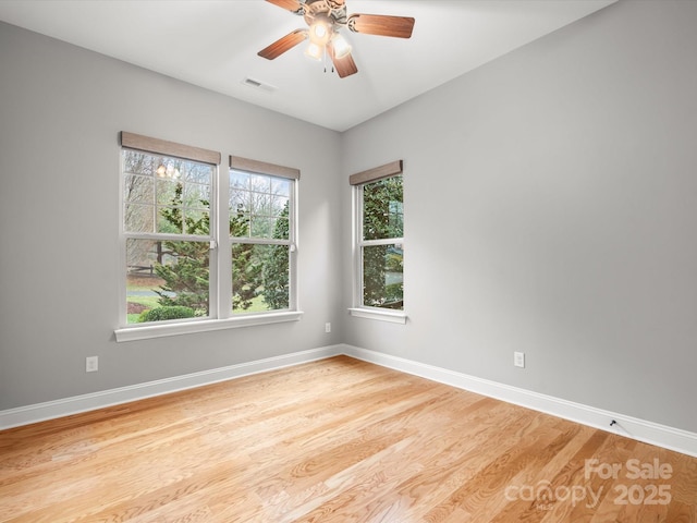 spare room featuring a ceiling fan, wood finished floors, visible vents, and baseboards