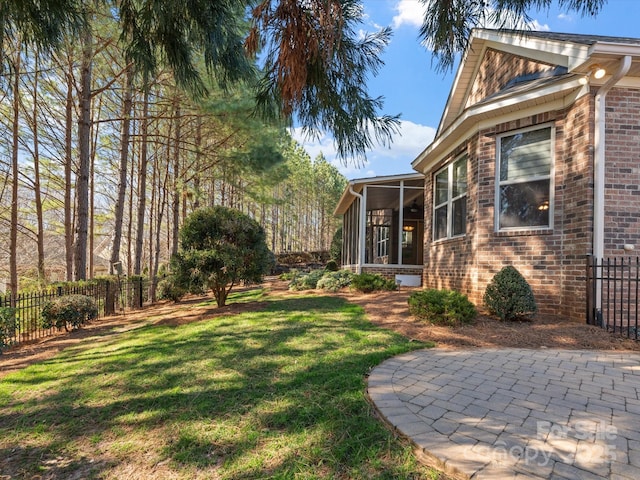 view of yard with a sunroom and fence