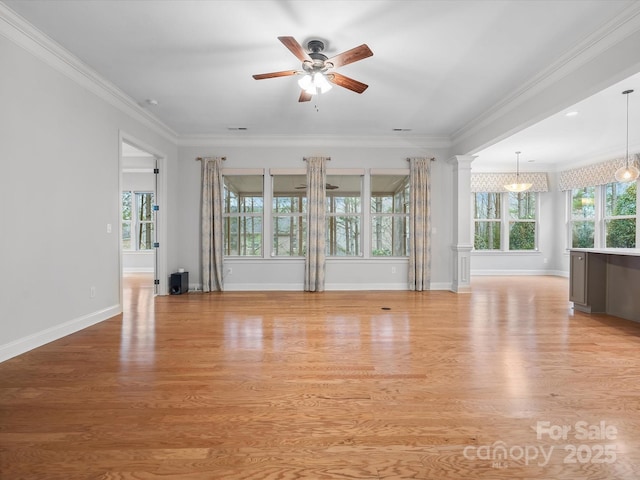 unfurnished room featuring baseboards, a ceiling fan, ornamental molding, light wood-type flooring, and ornate columns