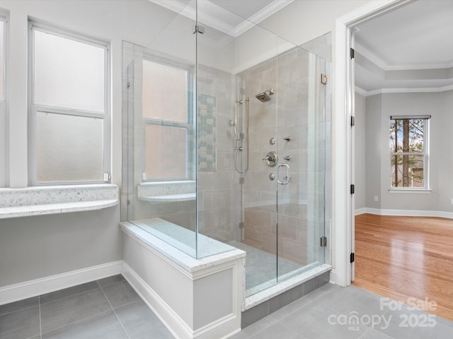 full bath featuring tile patterned flooring, a shower stall, baseboards, and crown molding