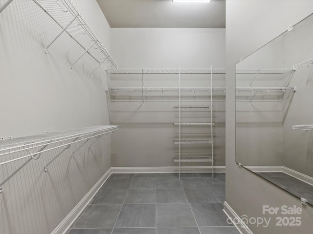 spacious closet with dark tile patterned flooring