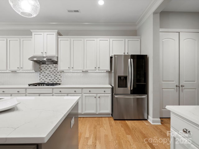 kitchen with ornamental molding, stainless steel appliances, light wood-type flooring, under cabinet range hood, and white cabinetry