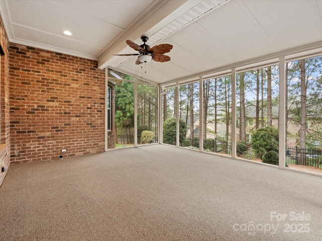 unfurnished sunroom with ceiling fan and vaulted ceiling with beams