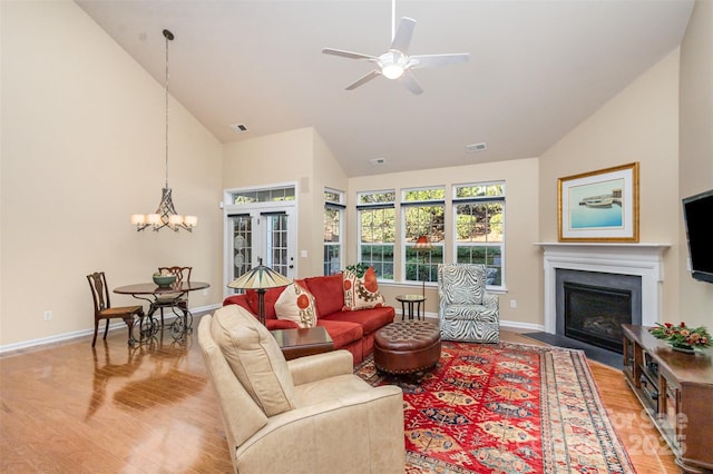 living room featuring high vaulted ceiling, wood-type flooring, french doors, and ceiling fan with notable chandelier