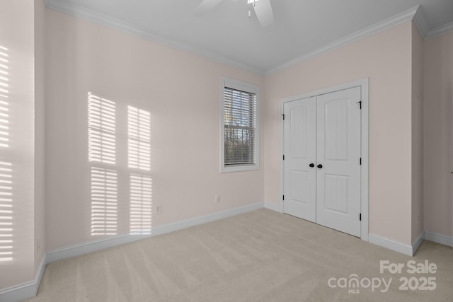 unfurnished bedroom featuring ceiling fan, light colored carpet, ornamental molding, and a closet