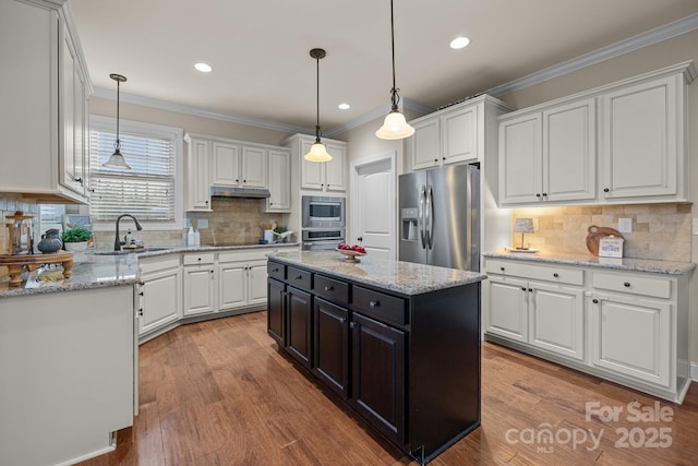 kitchen with a center island, stainless steel appliances, white cabinetry, and sink