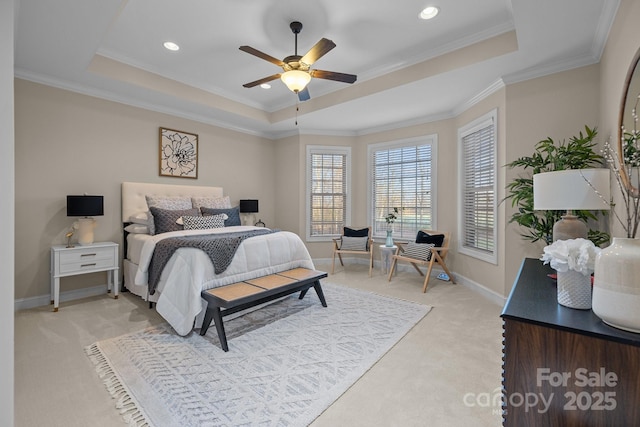 bedroom with ceiling fan, light colored carpet, crown molding, and a tray ceiling