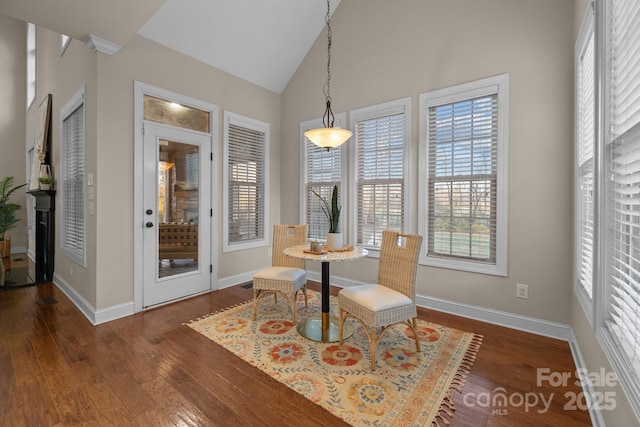 dining room with dark hardwood / wood-style floors and high vaulted ceiling