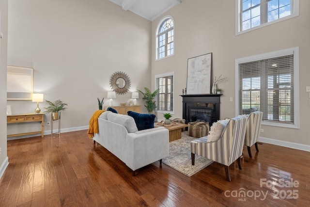 living room with hardwood / wood-style floors, plenty of natural light, beam ceiling, and high vaulted ceiling