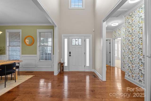 entrance foyer featuring plenty of natural light, wood-type flooring, and ornamental molding