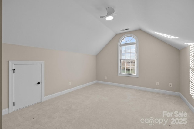 bonus room with ceiling fan, light carpet, and vaulted ceiling