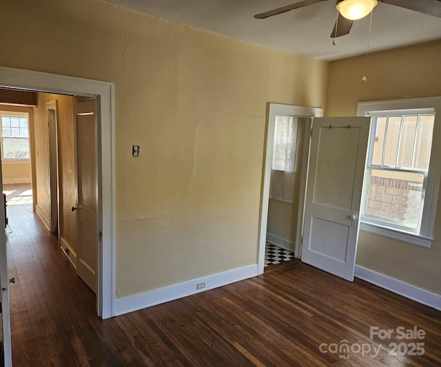 unfurnished room featuring ceiling fan and dark wood-type flooring