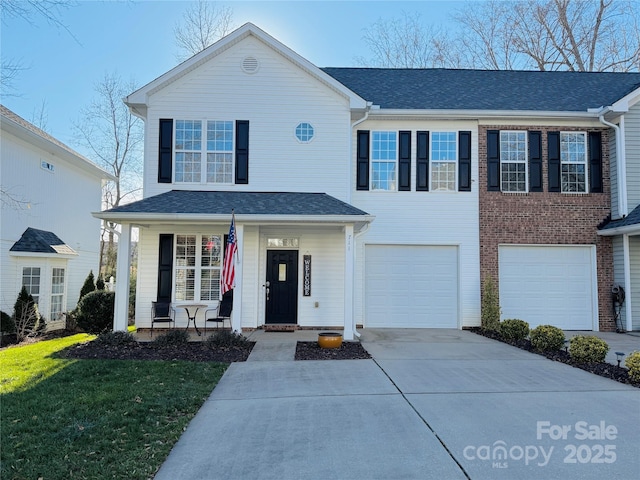 view of front of home featuring a garage, covered porch, and a front lawn