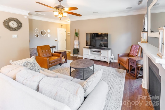 living room with dark hardwood / wood-style floors, ceiling fan, and ornamental molding