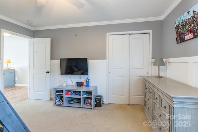 interior space featuring crown molding, ceiling fan, a closet, and light carpet