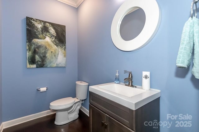 bathroom with vanity, toilet, and crown molding