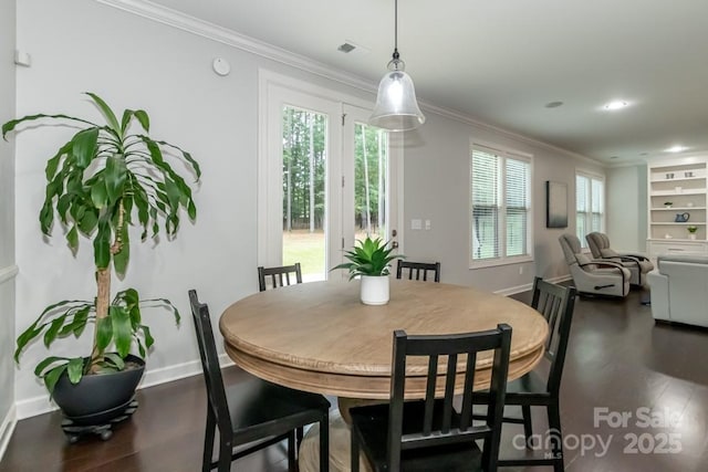 dining area featuring wood-type flooring and crown molding