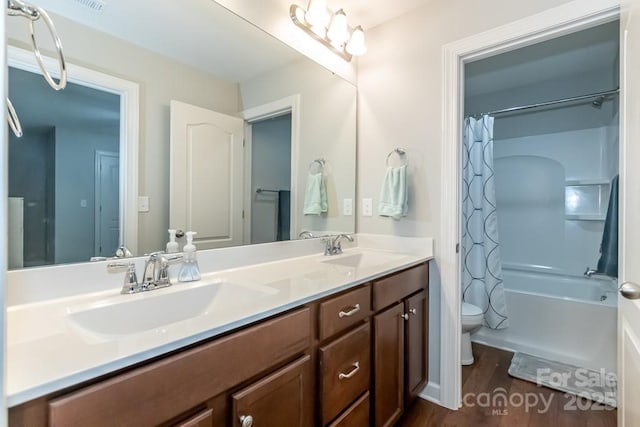 full bathroom with hardwood / wood-style floors, vanity, shower / bath combo, and toilet