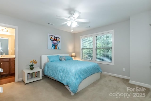 bedroom featuring ensuite bathroom, ceiling fan, and light carpet