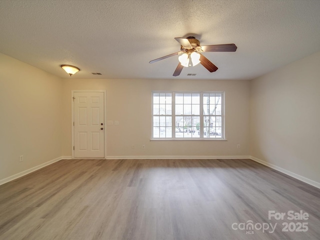 spare room featuring ceiling fan, a textured ceiling, and light hardwood / wood-style flooring