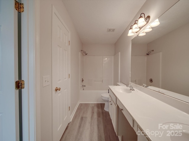 full bathroom featuring hardwood / wood-style floors, shower / bath combination, a textured ceiling, toilet, and vanity