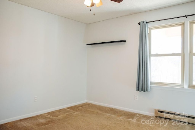 spare room with ceiling fan, carpet floors, and a baseboard heating unit