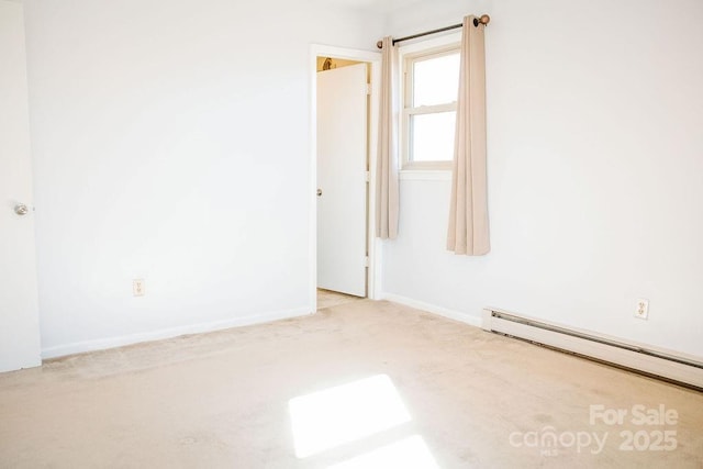 empty room with light colored carpet and a baseboard radiator