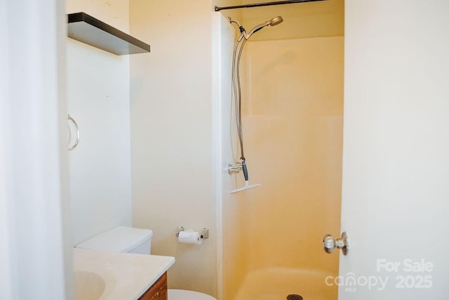 bathroom featuring vanity, toilet, and a shower