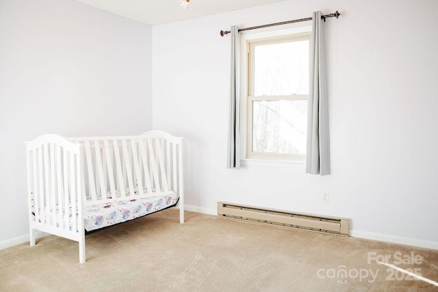 unfurnished bedroom featuring baseboard heating, carpet floors, and a nursery area