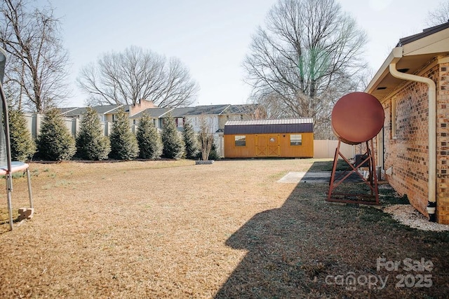 view of yard with a storage shed and a trampoline