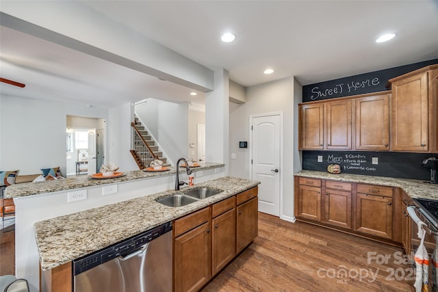 kitchen featuring decorative backsplash, light stone counters, stainless steel appliances, sink, and hardwood / wood-style floors