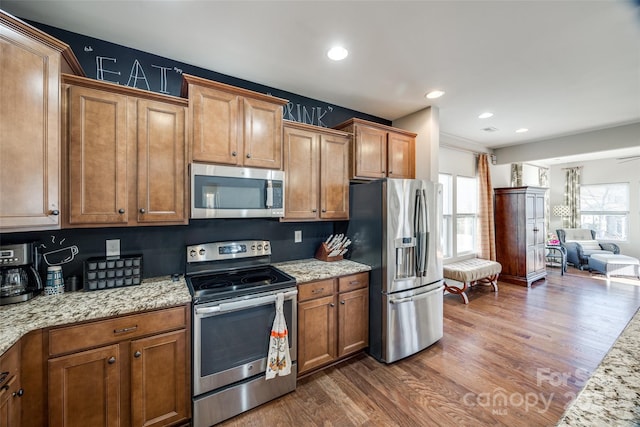 kitchen featuring light stone counters, dark hardwood / wood-style flooring, and appliances with stainless steel finishes