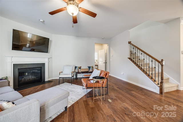 living room with ceiling fan and dark wood-type flooring