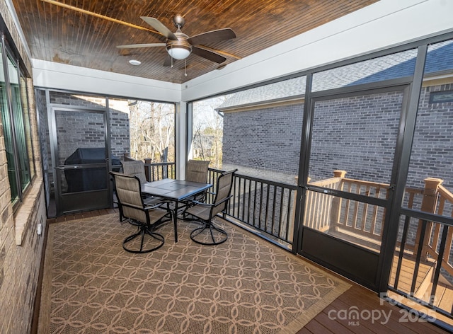 sunroom featuring ceiling fan and wood ceiling