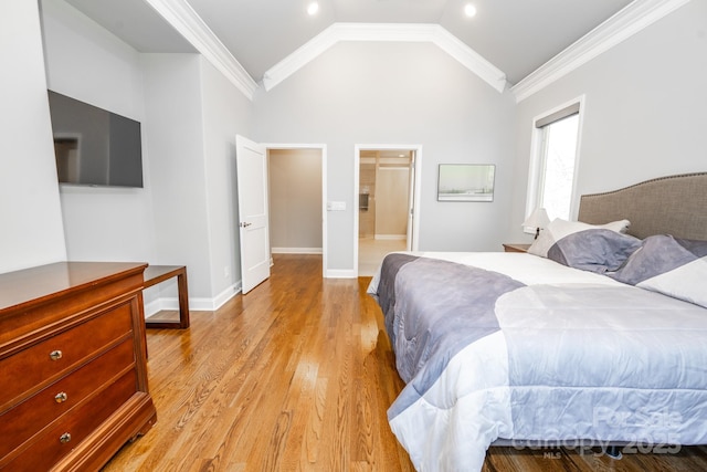 bedroom featuring lofted ceiling, light hardwood / wood-style floors, crown molding, and ensuite bathroom