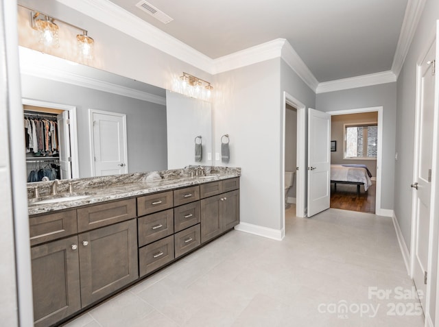 bathroom featuring tile patterned floors, vanity, toilet, and crown molding