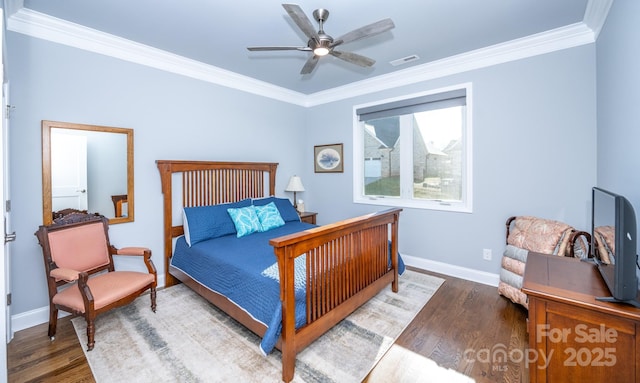 bedroom with ceiling fan, ornamental molding, and dark wood-type flooring